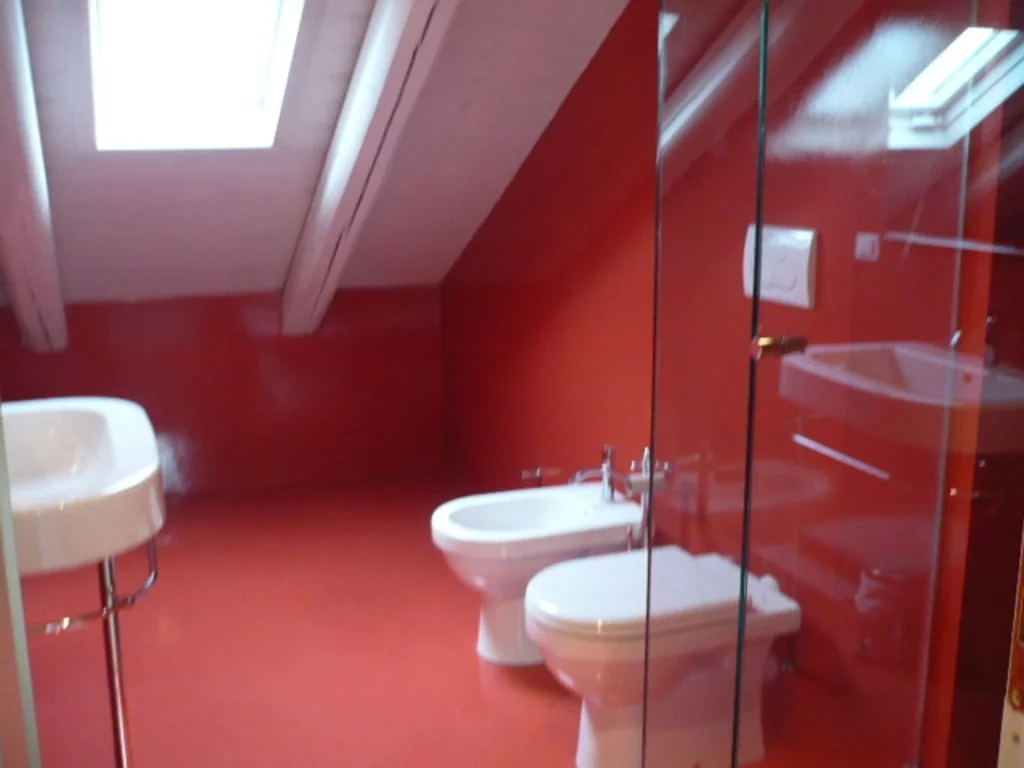Bagno in mansarda, rosso lucido. Soffitti tinteggiati a calce e cera.| Bathroom in attic, glossy red. Ceilings painted in lime and wax.
